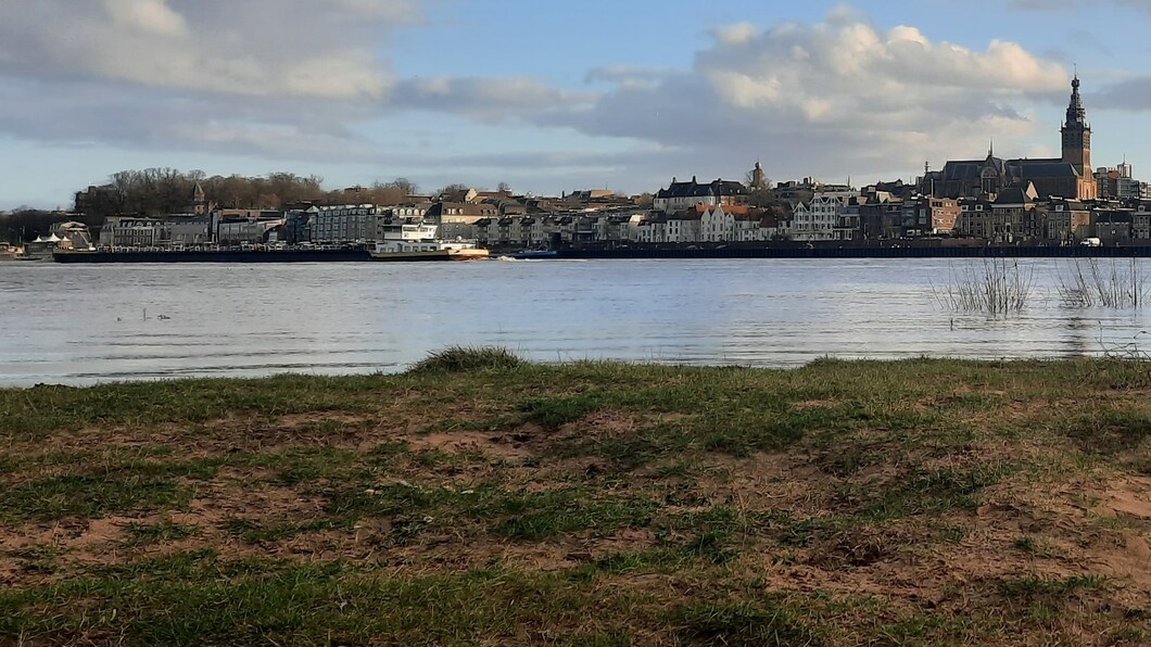 Zicht op Nijmegen en de Waal met vrachtboot