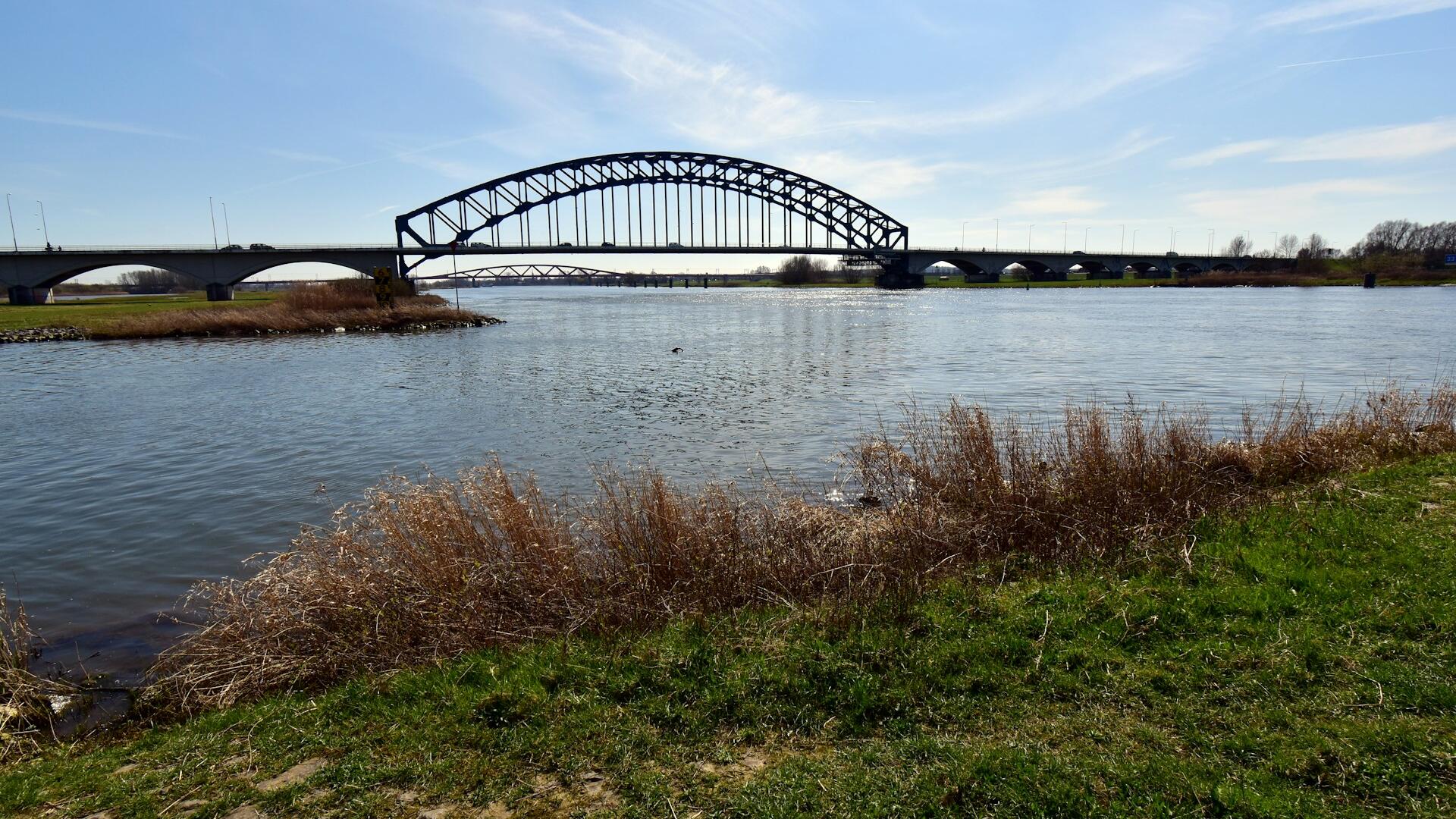 Brug over rivier in graslandschap