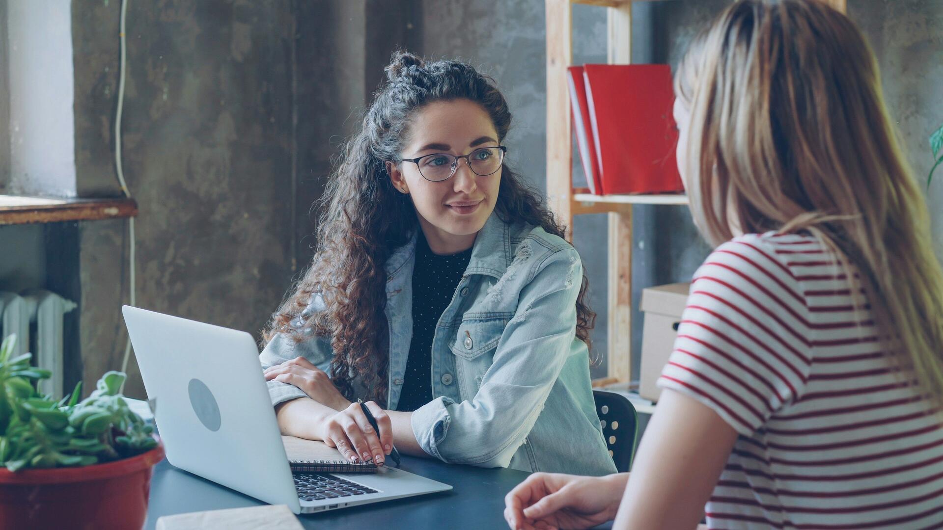 twee vrouwen achter een laptop in gesprek